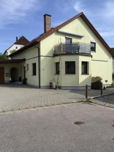 una casa bianca con un balcone sopra di Ferienwohnung Ernst a Riedenburg