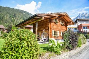 una cabaña de madera con una persona sentada fuera de ella en Almchalet Alpenflora, en Werfenweng