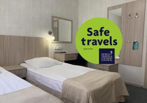una habitación de hotel con 2 camas y un letrero que lee viajes seguros en Matrix Hotel, en San Petersburgo