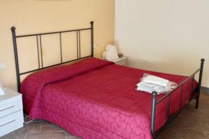 a bedroom with a bed with a red comforter at Appartamento rustico con vista in Montelupo Fiorentino
