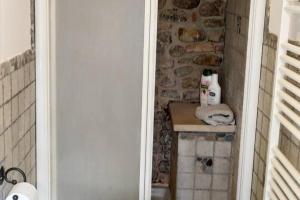 a bathroom with a stone wall and a sink at Appartamento rustico con vista in Montelupo Fiorentino
