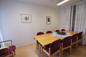 a dining room with a wooden table and chairs at Hellidens Slott in Tidaholm