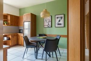 eine Küche mit einem Esstisch und Stühlen in der Unterkunft Travel Homes - The Wooden, Spacieux & bon quartier in Mulhouse