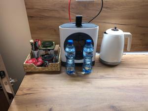 Your Place Apartment في مدينة فارنا: آلة صنع القهوة وزجاجتين من الماء على منضدة