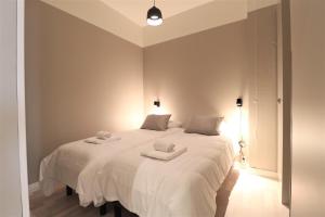 a bedroom with a large white bed with towels on it at Forenom Aparthotel Vaasa in Vaasa