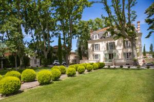 a large white house with a row of bushes at LES FRENES EN PROVENCE-CHÂTEAU ZEN in Avignon