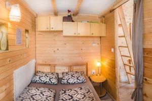 a bedroom with two beds in a wooden room at Tiny House Lavender in Podtureň +32 photos