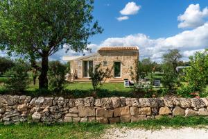 a stone house with a stone wall at Zahir Country House Hotel in Noto