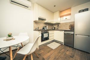 Una cocina con una mesa y un refrigerador blanco. en Villa Tara, en Zadar