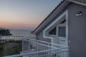 a house with a balcony with a view of the water at Amore Del Mare in Amoudi
