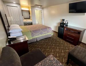 a bedroom with a bed and a dresser at Budget Lodge Eugene - Airport in Eugene