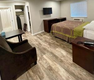una camera d'albergo con letto, scrivania e sedia di Budget Lodge Eugene - Airport a Eugene