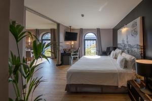 sypialnia z dużym białym łóżkiem i biurkiem w obiekcie 138 Liberdade Hotel w Lizbonie