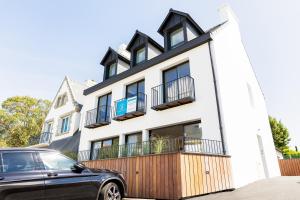 un coche negro estacionado frente a un edificio blanco en Résidence du Phare - 4 appartements - 2 chambres - Vue mer ou Terrasse, en Combrit