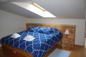 a bedroom with a bed with a blue comforter at RENMIR in Poprad