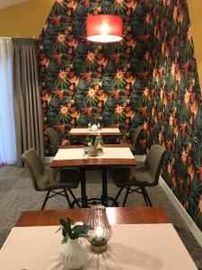 a table and chairs in a room with a floral wall at Boutique Hotel en B&B De Zwammenberg in De Moer