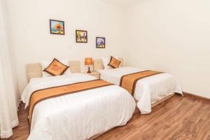 Ce lit se trouve dans un dortoir doté de murs blancs et de parquet. dans l'établissement VINATA 289 Khuất Duy Tiến, à Hanoï