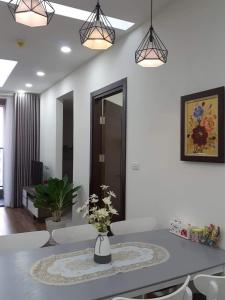 - une salle à manger avec une table et deux lampes pendant dans l'établissement VINATA 289 Khuất Duy Tiến, à Hanoï