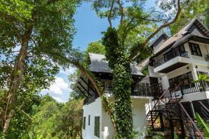 a white house with ivy growing on it at Patong Garden House - Luxury Villa in Patong Hills in Patong Beach