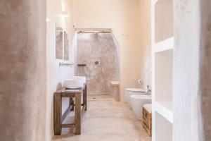 ein Badezimmer mit Dusche, Toilette und Waschbecken in der Unterkunft Di Lorenzi Albergo Diffuso in Felline
