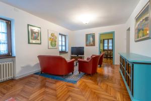 a living room with two chairs and a television at Hladik House - Alpi Giulie Cosy Apartment in Tarvisio