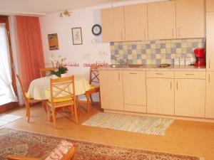 eine Küche mit einem Tisch und einem Waschbecken sowie einem Tisch und Stühlen in der Unterkunft Exklusive Lage - Wohnung mit schönem Garten - Hämmerle Yellow in Konstanz