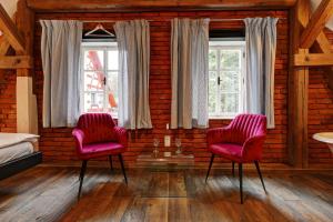 two red chairs in a room with two windows at Statek Salajna in Salajna