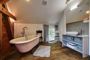 a bathroom with a large tub and a sink at Statek Salajna in Salajna