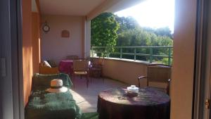 Habitación con balcón con mesa y sillas. en rossignol, en Chatuzange-le-Goubet