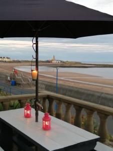 two red lights on a table with a view of the beach at Captains Lodge in Newbiggin-by-the-Sea