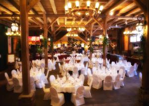 a large room with white tables and chairs and a chandelier at Hotel Restaurant Zur Post Lohfelden in Kassel