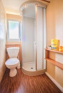 uma casa de banho com um WC e um chuveiro em Miramare Camping Village em Sottomarina