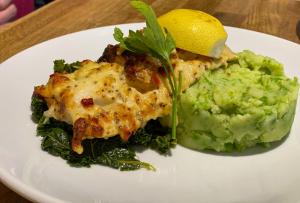 a plate of food with a piece of chicken and vegetables at The Golden Fleece Inn in Porthmadog