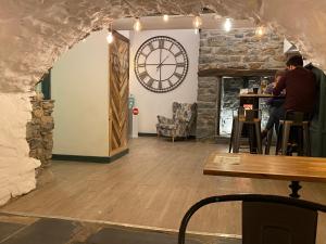 un restaurante con un reloj grande en la pared en The Golden Fleece Inn, en Porthmadog