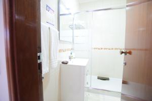 a bathroom with a sink, toilet and a window at Apartamentos Carruna in Albufeira