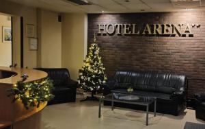 a living room with a christmas tree and leather furniture at Hotel Arena in Rybnik
