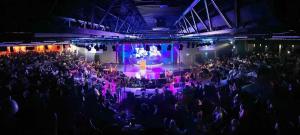 チャペル・セント・レオナルズにあるPg151 PALM GROVE THE GOLDEN PALM CHAPEL ST LEONARDSの演奏会を見る人々