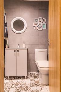 bagno con servizi igienici, lavandino e specchio di Studio T by MRG Apartments a Bucarest