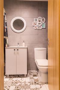 Un baño con inodoro, lavabo y espejo. en City Center - Studio T by MRG Apartments, en Bucarest 15 fotos más