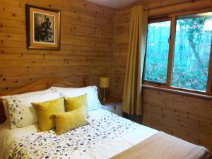 um quarto com uma cama com almofadas amarelas e uma janela em Willow Valley em Bude