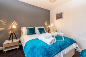 a bedroom with a bed with a blue bedspread at Guest Homes - New Street Apartment in Worcester