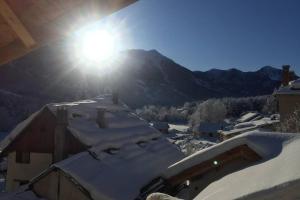 un tetto ricoperto di neve di una casa con il sole splendente di Le Grand PIerron Clarée Valley cosy apartment in mountain, 6p a Val-des-Prés Altre 5 foto
