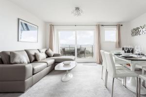 a living room with a couch and a table at Beach Point in Poole