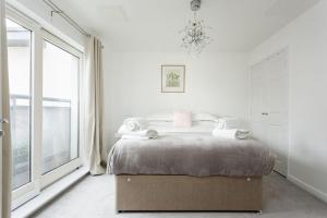 a bedroom with a bed and a large window at Beach Point in Poole