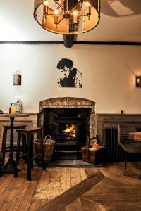 a living room with a fireplace and a chandelier at The Brown's Hotel in Laugharne