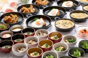 Dormy Inn Mito في ميتو: طاولة مليئة بأطباق الطعام على طاولة