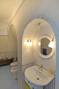 a bathroom with two toilets and a sink and a mirror at Casa Bouganville in Positano