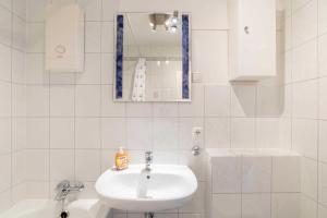 een witte badkamer met een wastafel en een spiegel bij Ferienwohnung Backbord in Schilksee