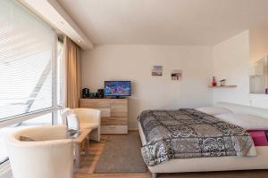 een slaapkamer met een bed, een tv en een raam bij Ferienwohnung Backbord in Schilksee