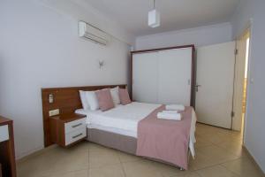 a bedroom with a bed and a dresser with towels on it at Infinity Olympia Apartments in Oludeniz +47 photos